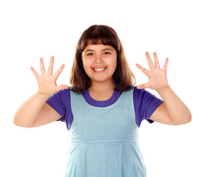 Portrait of smiling girl standing against white background