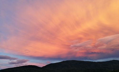 Low angle view of silhouette mountains against romantic sky