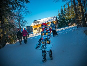 People in snow against sky during winter