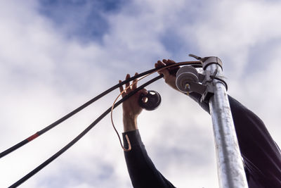Low angle view of man holding umbrella against sky