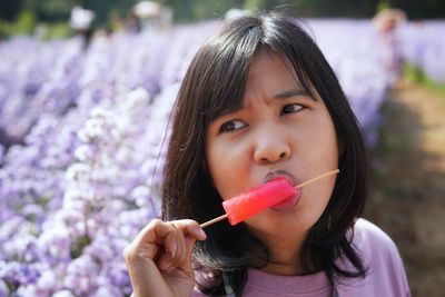 Close-up portrait of a girl holding pink flower