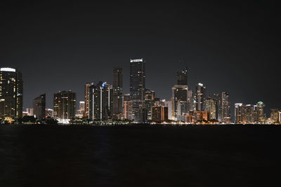 Illuminated buildings in city against sky at night