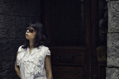 Woman in sunglasses standing against closed door