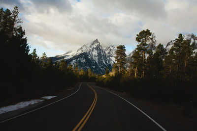 Road amidst snowcapped mountains against sky