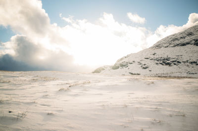 Scenic view of mountains against cloudy sky