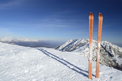 Scenic view of snow covered mountains against blue sky