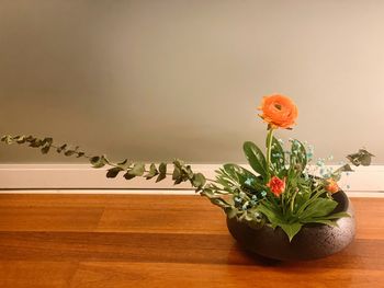 Flower vase on table against wall