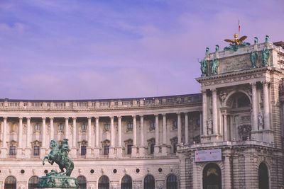 Statue of historic building against cloudy sky