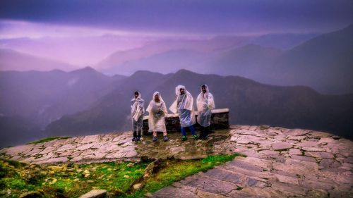 People standing on mountain against sky