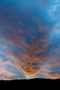 Scenic view of dramatic sky over silhouette landscape