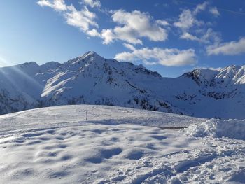 Scenic view of snow covered mountains against sky