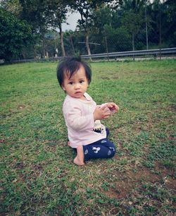 Portrait of cute baby girl on field