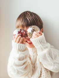 Kid with decorative balls for christmas tree.boy in cable-knit oversized sweater.new year.