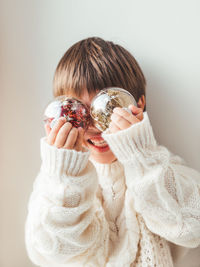 Portrait of woman holding ice cream against white background