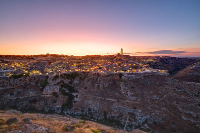 The beautiful old town of matera and the canyon of the gravina river after sunset