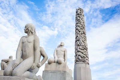 Low angle view of vigeland sculpture park against cloudy sky