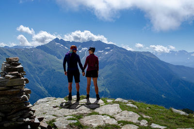 Rear view of people walking on mountain against sky