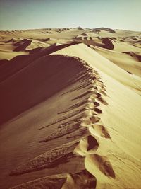 Sand dunes in desert against clear sky