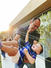 Side view of mother carrying daughter at home