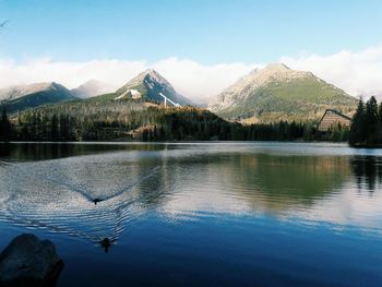 Scenic view of lake by snowcapped mountains against sky