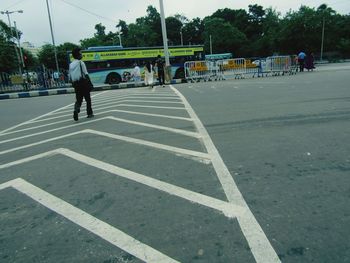 Rear view of people walking on road in city