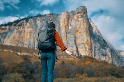 Rear view of person on rock against mountains