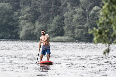 Man paddleboarding in lake