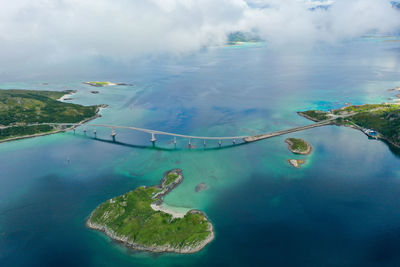 Drone view of turquoise ocean, islands and a bridge in northern norway