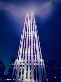 Low angle view of illuminated buildings against sky at night