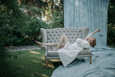 Woman lying on chair in yard