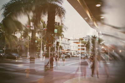 Blurred motion of people walking on street seen through glass window