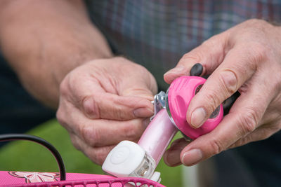 Close-up of hands adjusting bell on bicycle handle