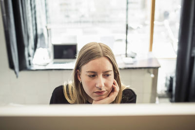 Young businesswoman using computer in creative office