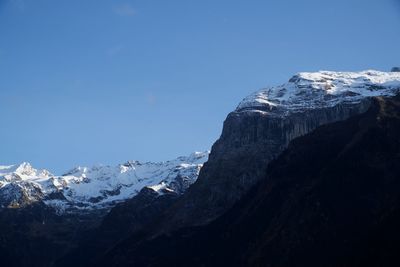 Scenic view of snowcapped mountains against blue sky