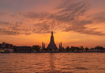 View of mosque and buildings against sky during sunset