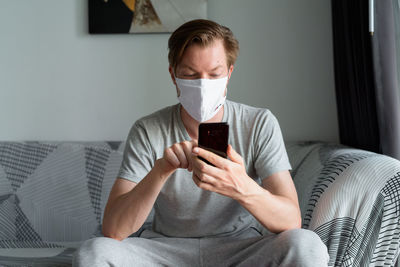 Man using mobile phone while sitting on sofa