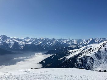 Scenic view of snowcapped mountains against clear blue sky