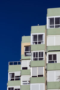 Low angle view of residential building against clear blue sky