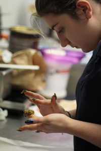 Side view of young woman holding flower