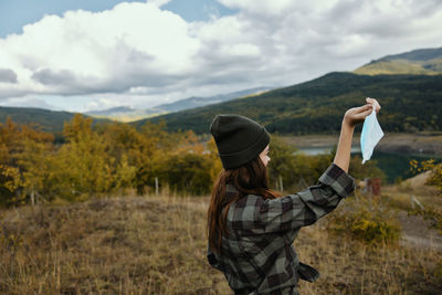 Woman holding face mask outdoors