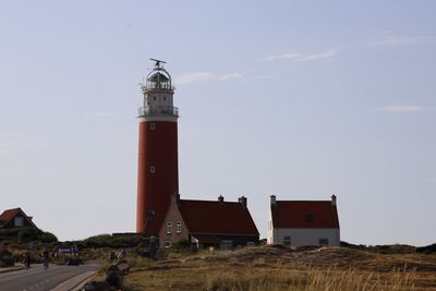 Lighthouse by sea against sky