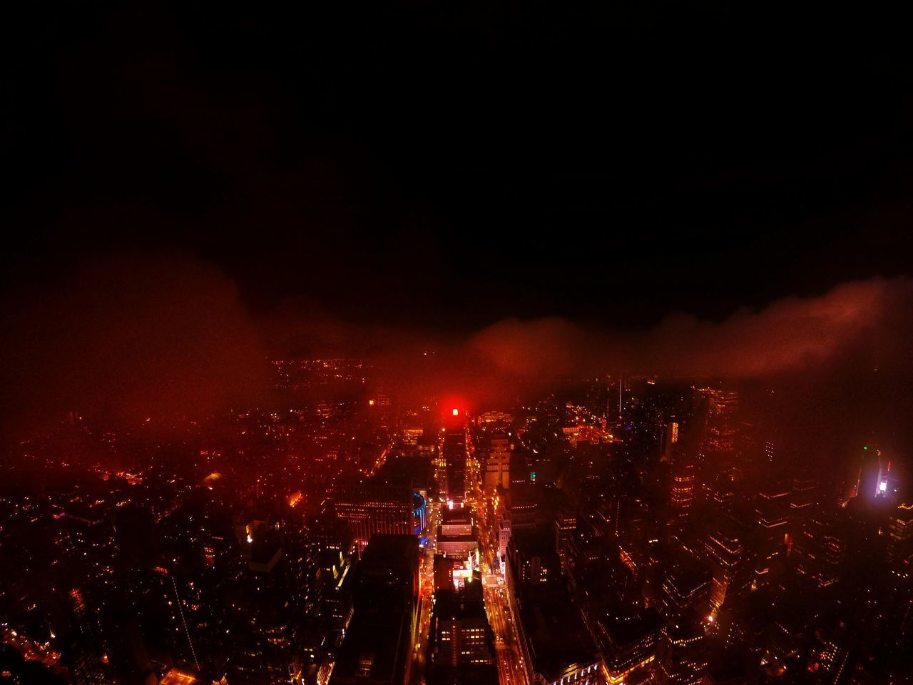 HIGH ANGLE VIEW OF ILLUMINATED CITY BUILDINGS AT NIGHT