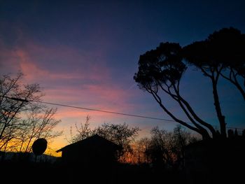 Low angle view of silhouette trees against sky at sunset