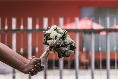 Close-up of woman hands holding flower bouquet outdoors