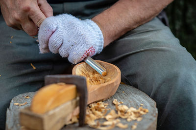 Midsection of man making wooden artwork