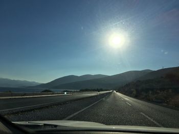 Road by mountains against sky