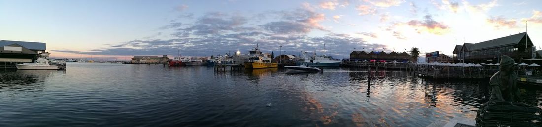 Boats moored in lake against sky in city