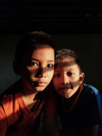 Portrait of brothers in darkroom