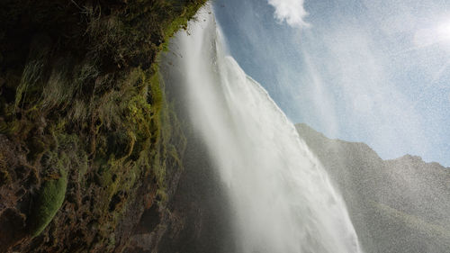 Scenic view of waterfall against sky