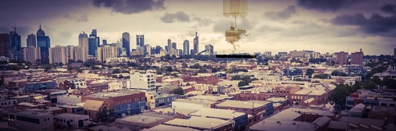 Cityscape against cloudy sky